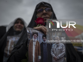 A veiled Iranian protester holds a poster featuring portraits of the former commander of the Islamic Revolutionary Guard Corps' (IRGC) Quds...