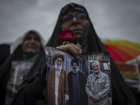 A veiled Iranian protester holds a poster featuring portraits of the former commander of the Islamic Revolutionary Guard Corps' (IRGC) Quds...