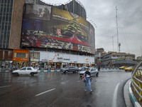 A young Iranian woman walks under an anti-Israeli giant billboard before a protest gathering to condemn an Israeli air strike against Hezbol...