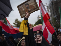 A veiled Iranian protester mourns while holding a framed portrait of Lebanon's Hezbollah Secretary General, Hassan Nasrallah, during a prote...