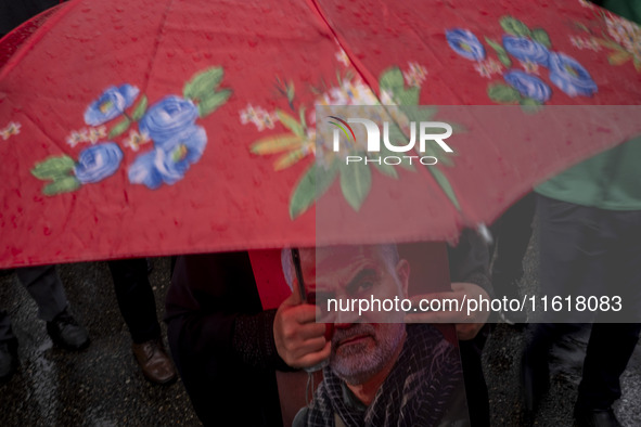 A veiled Iranian protester holds a portrait of the former commander of the Islamic Revolutionary Guard Corps' (IRGC) Quds Force, General Qas...