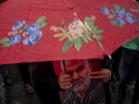 A veiled Iranian protester holds a portrait of the former commander of the Islamic Revolutionary Guard Corps' (IRGC) Quds Force, General Qas...