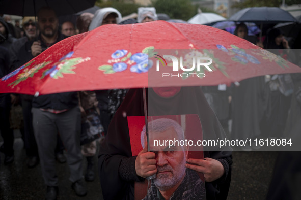 A veiled Iranian protester holds a portrait of the former commander of the Islamic Revolutionary Guard Corps' (IRGC) Quds Force, General Qas...