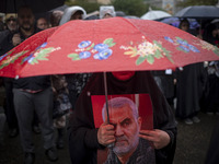 A veiled Iranian protester holds a portrait of the former commander of the Islamic Revolutionary Guard Corps' (IRGC) Quds Force, General Qas...