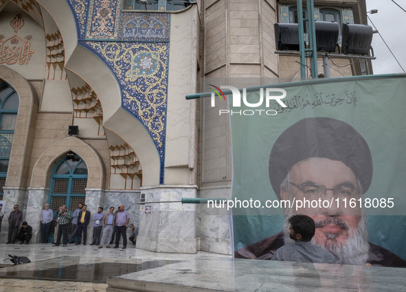 A man adjusts a billboard featuring a portrait of Lebanon's Hezbollah Secretary General, Hassan Nasrallah, during a protest gathering to con...