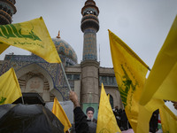 Iranian protesters wave Lebanon's Hezbollah flags next to a portrait of Hezbollah Secretary General, Hassan Nasrallah, during a protest gath...