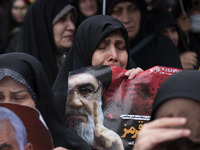 A veiled Iranian protester mourns while holding a portrait of Lebanon's Hezbollah Secretary General, Hassan Nasrallah, during a protest gath...