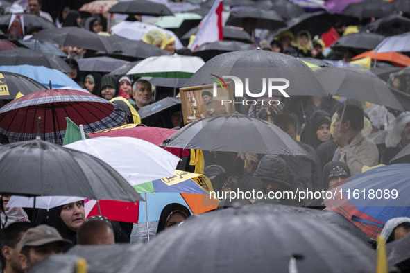 An Iranian protester (not pictured) holds up a framed portrait of Lebanon's Hezbollah Secretary General, Hassan Nasrallah, during a protest...