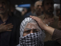 An Iranian woman wearing a Palestinian scarf beats herself while taking part in a protest gathering to condemn an Israeli air strike against...