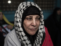 An Iranian woman wearing a Palestinian scarf mourns while taking part in a protest gathering to condemn an Israeli air strike against Hezbol...