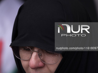 A veiled Iranian woman mourns while taking part in a protest gathering to condemn an Israeli air strike against Hezbollah's headquarters in...