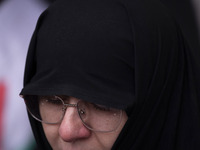 A veiled Iranian woman mourns while taking part in a protest gathering to condemn an Israeli air strike against Hezbollah's headquarters in...