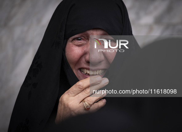 A veiled woman mourns while taking part in a protest gathering to condemn an Israeli air strike against Hezbollah's headquarters in the subu...