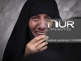 A veiled woman mourns while taking part in a protest gathering to condemn an Israeli air strike against Hezbollah's headquarters in the subu...