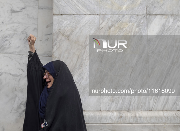 A veiled Iranian woman shouts anti-Israeli and anti-U.S. slogans while mourning during a protest gathering to condemn an Israeli air strike...