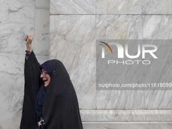 A veiled Iranian woman shouts anti-Israeli and anti-U.S. slogans while mourning during a protest gathering to condemn an Israeli air strike...