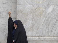 A veiled Iranian woman shouts anti-Israeli and anti-U.S. slogans while mourning during a protest gathering to condemn an Israeli air strike...