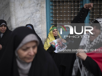 An Iranian woman holds a portrait of the former commander of the Islamic Revolutionary Guard Corps' (IRGC) Quds Force, General Qassem Soleim...