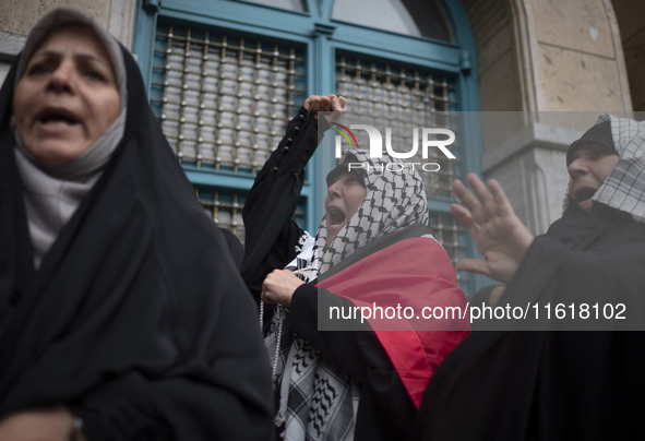 A female protester wearing a Palestinian scarf shouts anti-U.S. and anti-Israeli slogans during a protest gathering to condemn an Israeli ai...