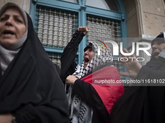 A female protester wearing a Palestinian scarf shouts anti-U.S. and anti-Israeli slogans during a protest gathering to condemn an Israeli ai...