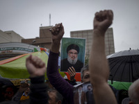 An Iranian protester holds up a portrait of Lebanon's Hezbollah Secretary General, Hassan Nasrallah, during a protest gathering to condemn a...