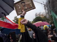 A veiled Iranian protester shouts anti-Israeli and anti-U.S. slogans while holding a framed portrait of Lebanon's Hezbollah Secretary Genera...