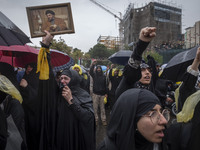 A veiled Iranian protester holds up a framed portrait of Lebanon's Hezbollah Secretary General, Hassan Nasrallah, who was killed in an Israe...