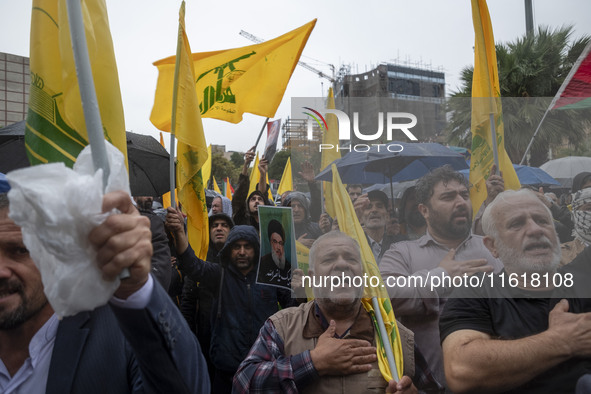 Iranian protesters beat themselves while taking part in a protest gathering to condemn an Israeli air strike against Hezbollah's headquarter...