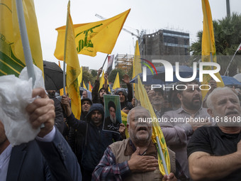 Iranian protesters beat themselves while taking part in a protest gathering to condemn an Israeli air strike against Hezbollah's headquarter...