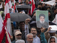 An Iranian protester holds up a portrait of Lebanon's Hezbollah Secretary General, Hassan Nasrallah, during a protest gathering to condemn a...