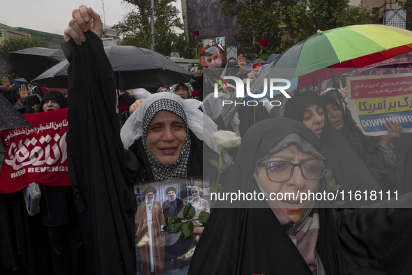 A veiled Iranian protester shouts anti-Israeli and anti-U.S. slogans while holding a poster featuring portraits of the former commander of t...