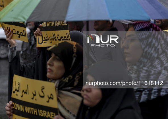 Veiled Iranian protesters hold anti-Israeli placards while taking part in a protest gathering to condemn an Israeli air strike against Hezbo...