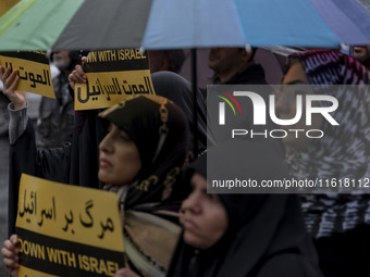 Veiled Iranian protesters hold anti-Israeli placards while taking part in a protest gathering to condemn an Israeli air strike against Hezbo...