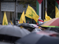 Iranian protesters wave Lebanon's Hezbollah flags during a protest gathering to condemn an Israeli air strike against Hezbollah's headquarte...