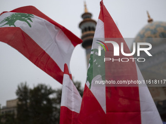 Veiled protesters (not pictured) wave Lebanese flags during a protest gathering to condemn an Israeli air strike against Hezbollah's headqua...