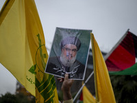 An Iranian protester holds up a portrait of Lebanon's Hezbollah Secretary General, Hassan Nasrallah, during a protest gathering to condemn a...