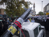 A scaled model of Iran's first ultrasonic missile (Fattah) is carried by a truck during a protest gathering to condemn an Israeli air strike...