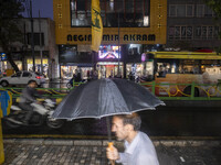 An Iranian man walks past a Hezbollah flag hanging on a sidewalk as a sign of unity with Hezbollah and the Lebanese people in Tehran, Iran,...