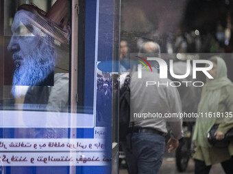 Iranian people walk past a portrait of Lebanon's Hezbollah Secretary General, Hassan Nasrallah, in Tehran, Iran, on September 28, 2024. Leba...