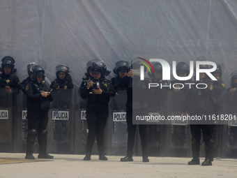 Policewomen guard women marching in Mexico City, Mexico, on September 28, 2024, from the Glorieta de las Mujeres que Luchan to the Zocalo on...