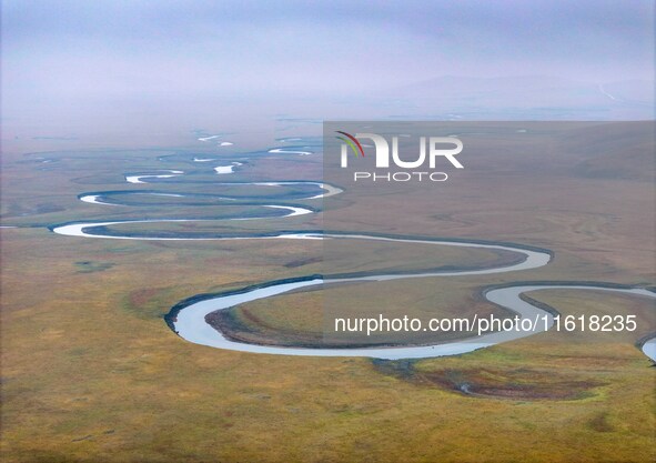 An aerial photo taken in Hulunbuir, China, on September 28, 2024, shows the winding Mogoler River passing through the grassland during autum...