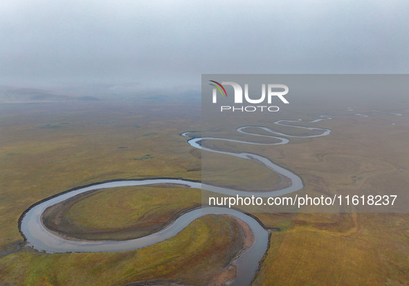 An aerial photo taken in Hulunbuir, China, on September 28, 2024, shows the winding Mogoler River passing through the grassland during autum...