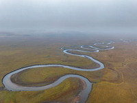 An aerial photo taken in Hulunbuir, China, on September 28, 2024, shows the winding Mogoler River passing through the grassland during autum...