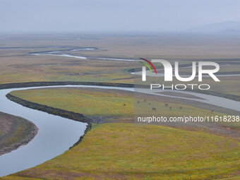 An aerial photo taken in Hulunbuir, China, on September 28, 2024, shows the winding Mogoler River passing through the grassland during autum...