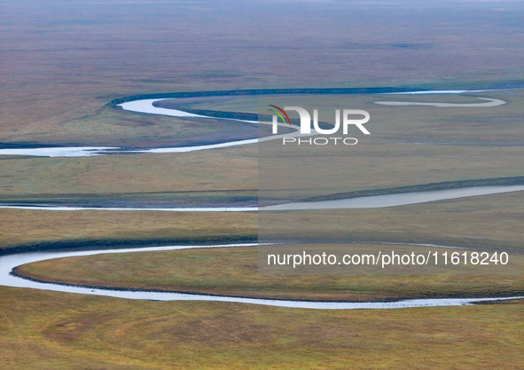 An aerial photo taken in Hulunbuir, China, on September 28, 2024, shows the winding Mogoler River passing through the grassland during autum...