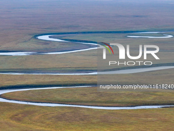 An aerial photo taken in Hulunbuir, China, on September 28, 2024, shows the winding Mogoler River passing through the grassland during autum...