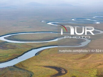 An aerial photo taken in Hulunbuir, China, on September 28, 2024, shows the winding Mogoler River passing through the grassland during autum...