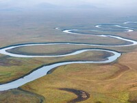 An aerial photo taken in Hulunbuir, China, on September 28, 2024, shows the winding Mogoler River passing through the grassland during autum...