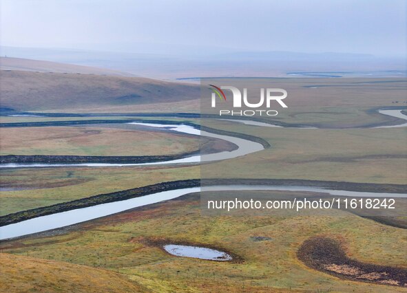 An aerial photo taken in Hulunbuir, China, on September 28, 2024, shows the winding Mogoler River passing through the grassland during autum...