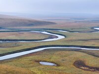 An aerial photo taken in Hulunbuir, China, on September 28, 2024, shows the winding Mogoler River passing through the grassland during autum...